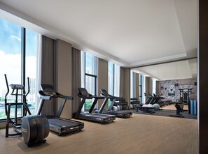 A modern gym with treadmills, elliptical machines, and exercise balls.