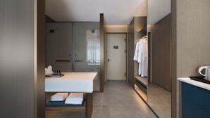Een moderne badkamer met een grote spiegel, een wastafel en een handdoekhouder.