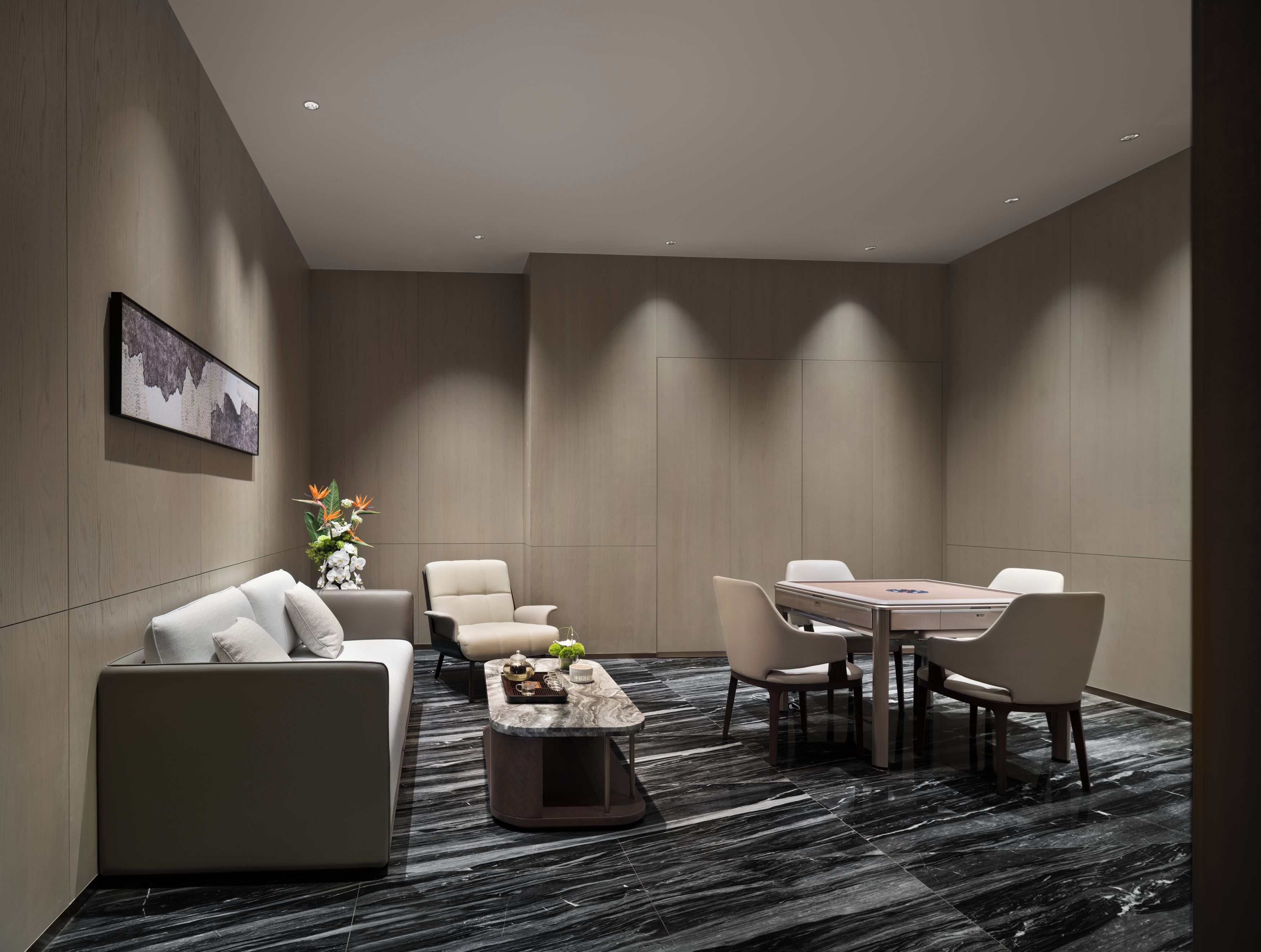 Een moderne hotelkamer met een bank, fauteuils, een eettafel en een salontafel.