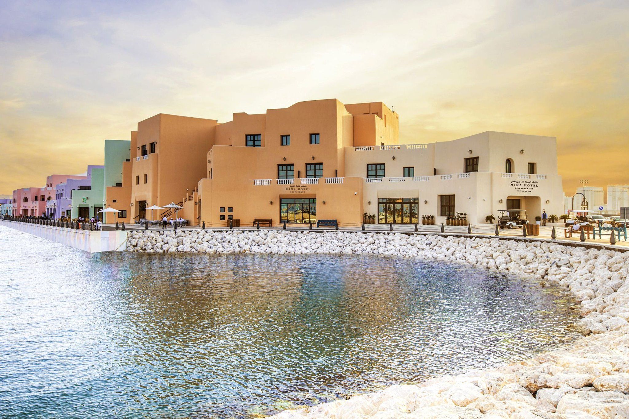 Un hotel frente al mar con costa rocosa, varias construcciones y cielo despejado.