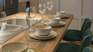 Una cocina moderna con encimera de madera, pileta integrada y sillas tapizadas en verde.