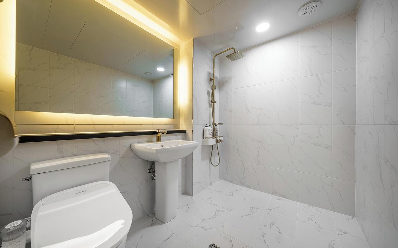 Un baño moderno con inodoro, lavamanos y ducha.