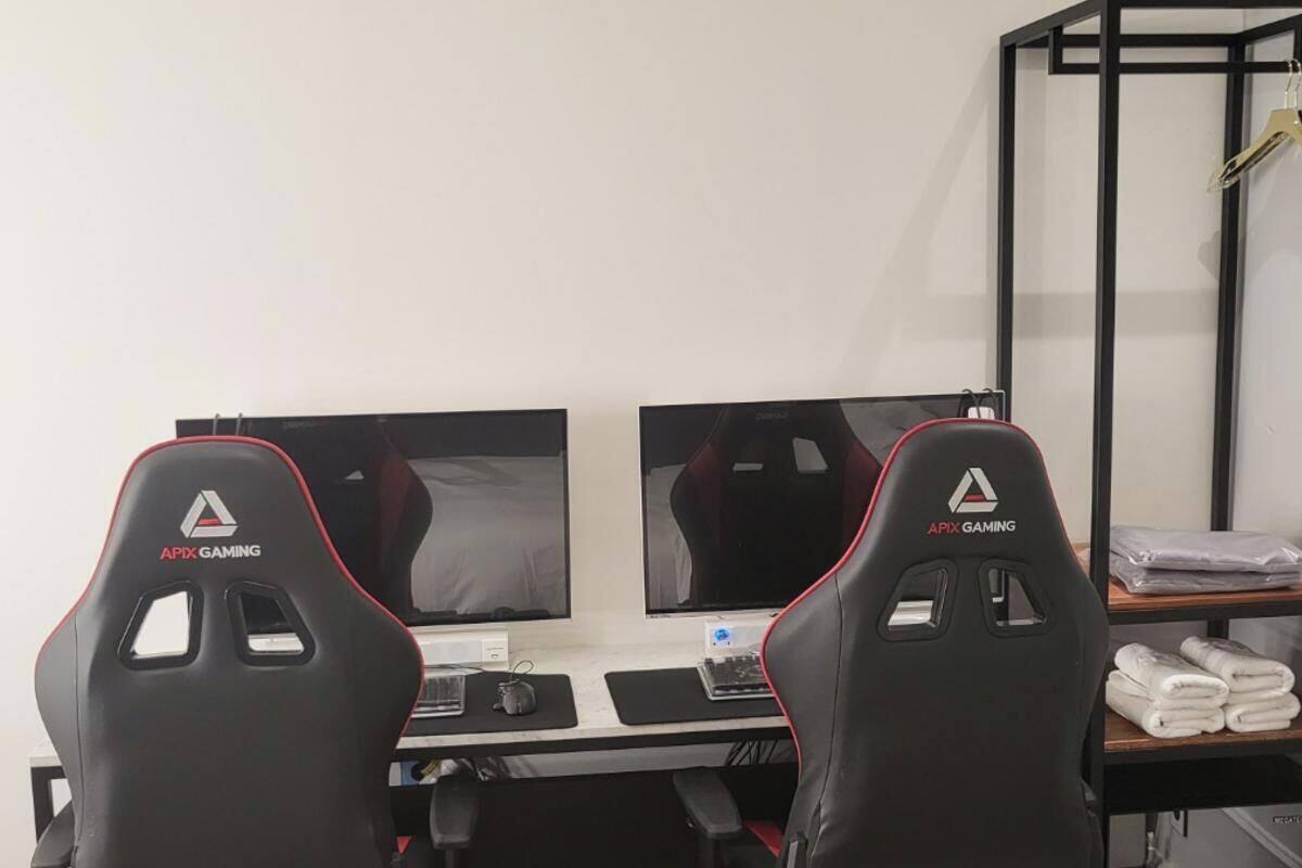 Un'area dedicata al gaming con due monitor, due sedie da gaming Apex, e una scrivania con tastiera, mouse e sottotavolo per il mouse.