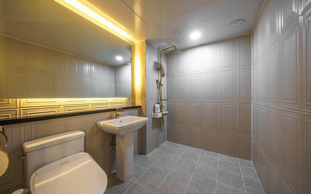 Un baño moderno con inodoro, lavabo y ducha.