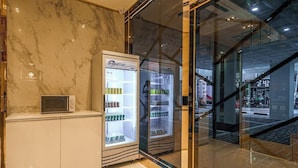 Un interior moderno con una pared de mármol, un microondas y dos refrigeradores de la marca Freetop.
