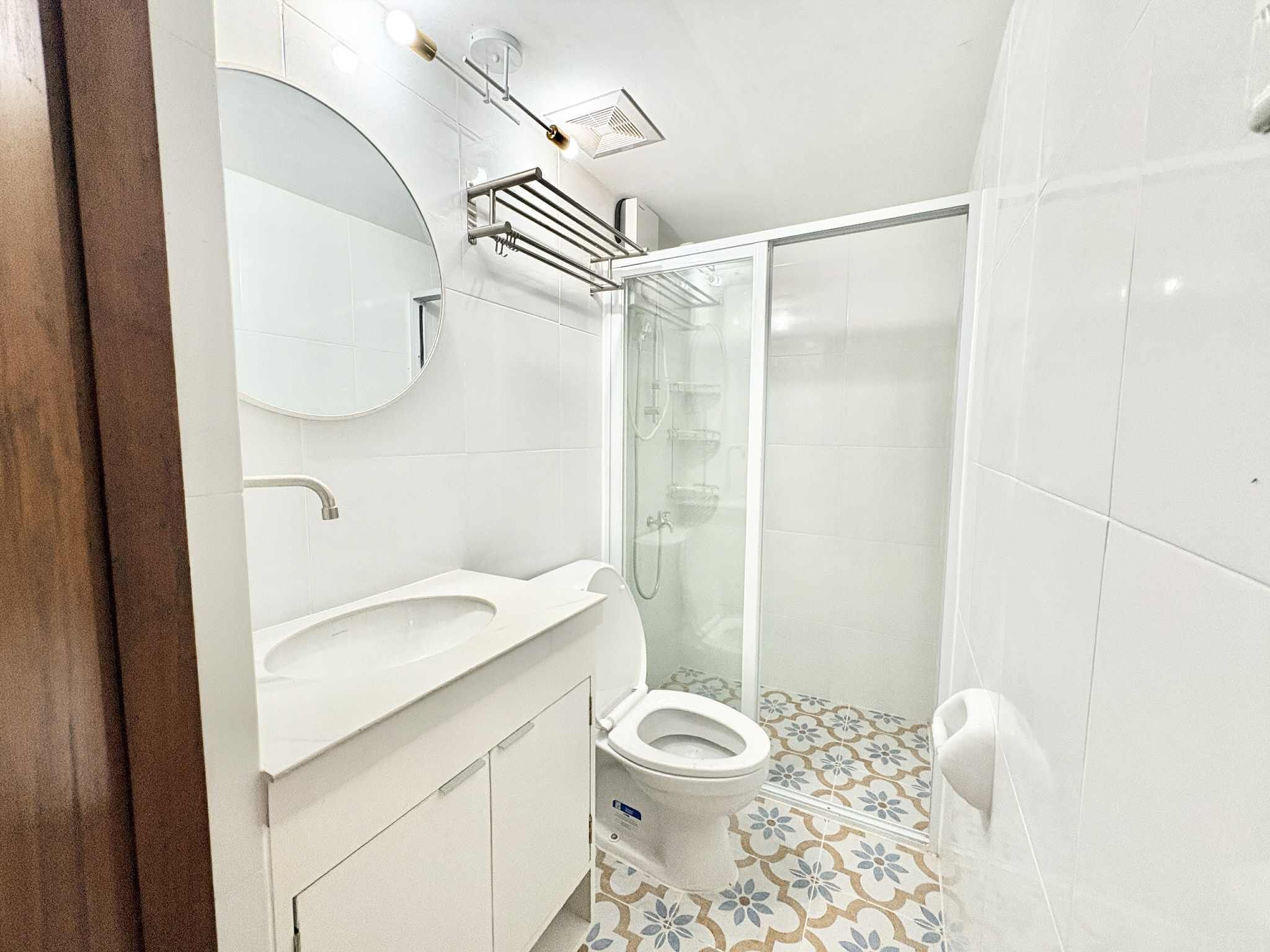A bathroom with a white sink, toilet, and shower area.
