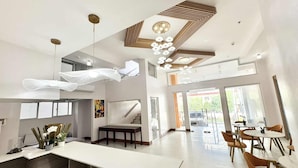 A spacious hotel lobby with a long reception desk, multiple seating areas, and a staircase leading to upper floors. - Palette Cebu The Almonds Boutique Aparthotel Near University of Cebu (Cebu City)