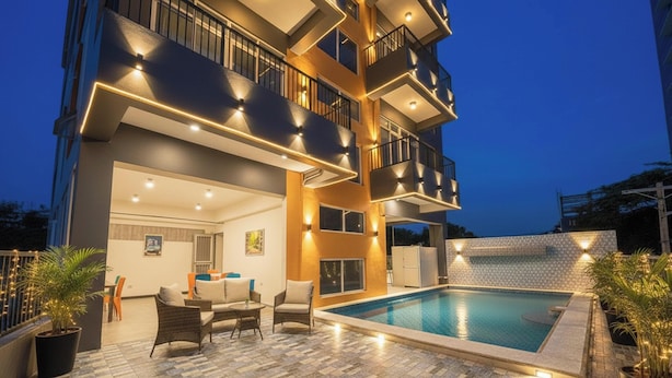 A multi-story building with a rooftop pool, outdoor seating, and balconies. - Palette Cebu The Almonds Boutique Aparthotel Near University of Cebu (Cebu City)