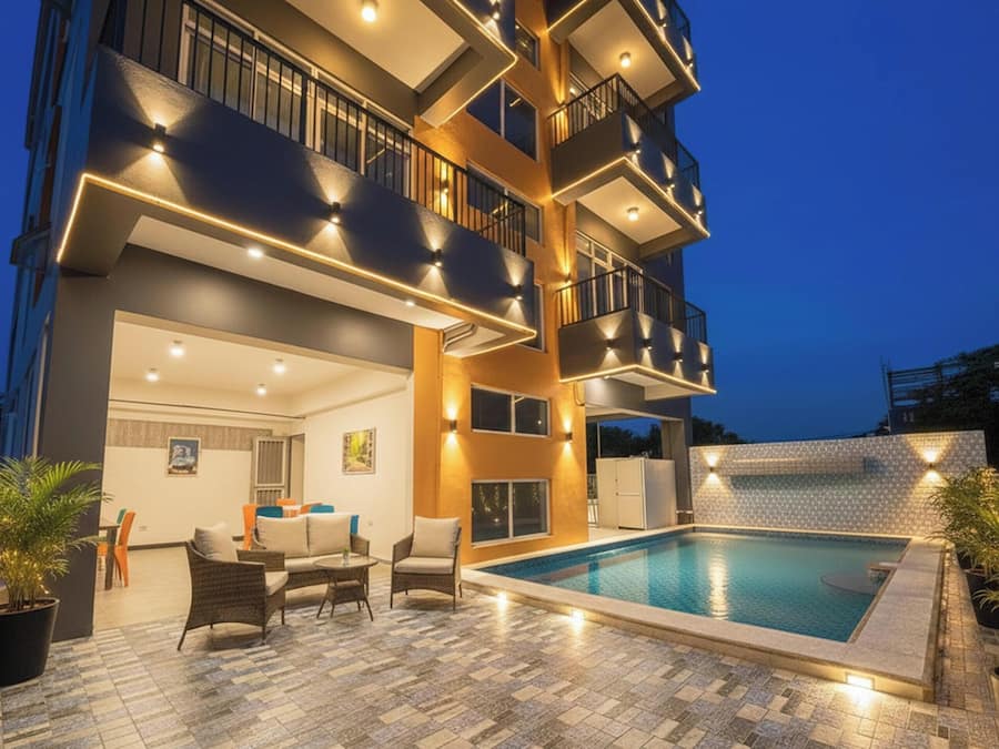 A multi-story building with a rooftop pool, outdoor seating, and balconies.