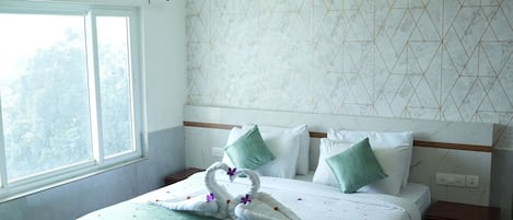 A neatly made bed with a green and white bedspread, a wooden headboard, and a nightstand with a lamp.