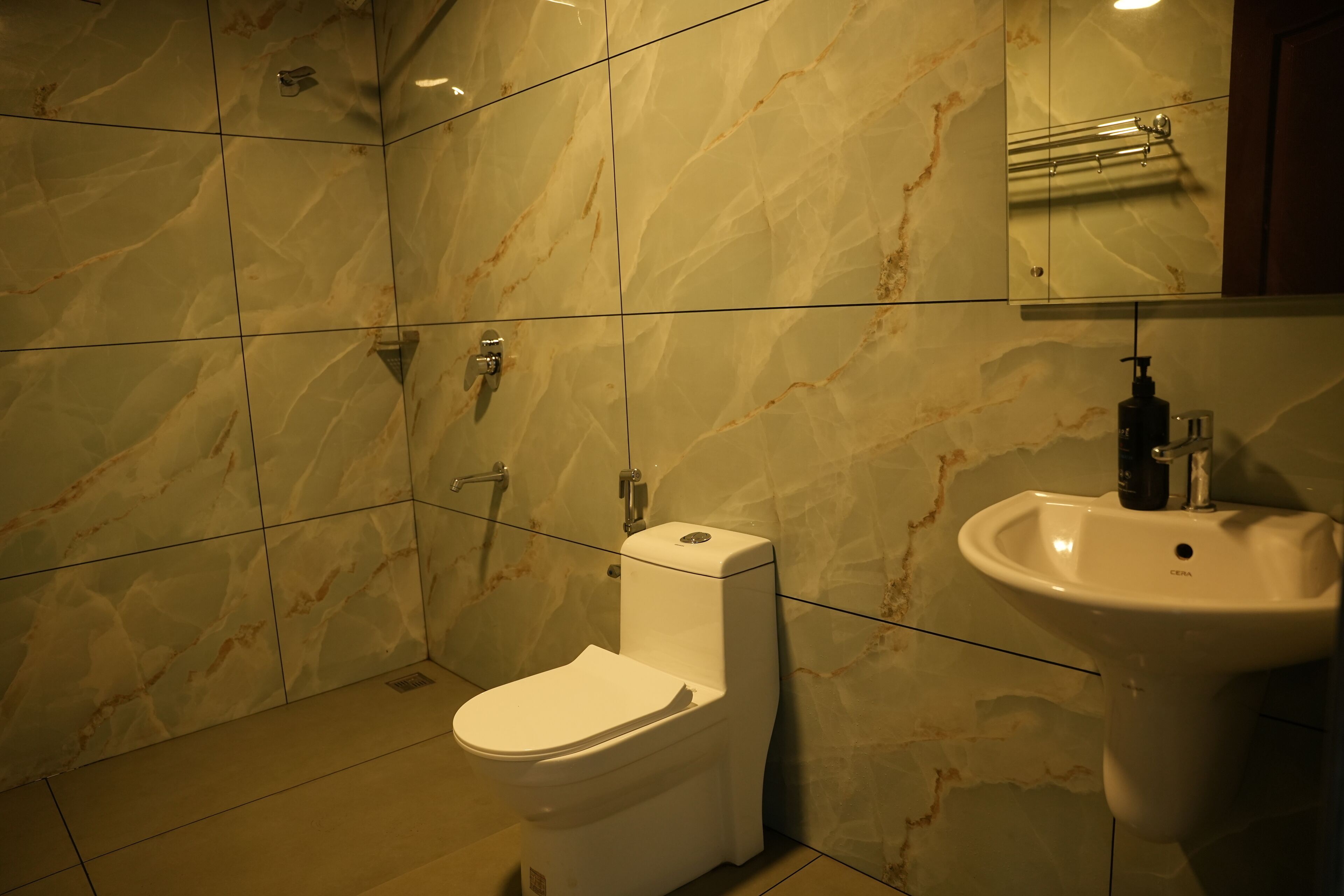A bathroom with a toilet, sink, and mirror.