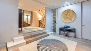 A modern interior with a staircase leading to a second floor, a piano, and a large abstract wall art piece. - Prestigious 5BR Avenue Foch Home - Arc de Triomphe (Paris)