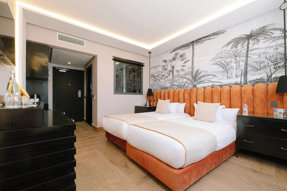 Una habitación de hotel moderna con una cama grande, un escritorio y un mural en la pared.
