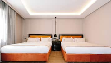 A hotel room with two beds, a nightstand, a lamp, and a ceiling light.