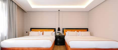 Habitación de hotel con dos camas, una mesita de noche, una lámpara y una luz en el techo.