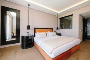 Ein modernes Hotelzimmer mit einem großen Bett, Nachttischen, einem Spiegel und Blick auf die Stadt.
