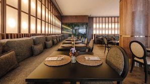 A restaurant with a long dining area, high wooden walls, and a modern interior design.
