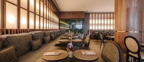 A restaurant with a long dining area, high wooden walls, and a modern interior design.