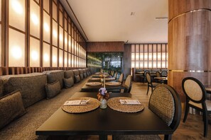 Un restaurante con un amplio salón comedor, paredes de madera y una decoración de estilo moderno.