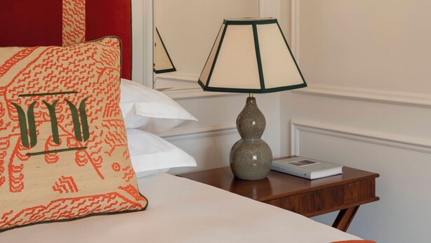 A hotel room with a bed, a nightstand, a lamp, and a mirror. - Miralago Luxury Apartments (Cernobbio)