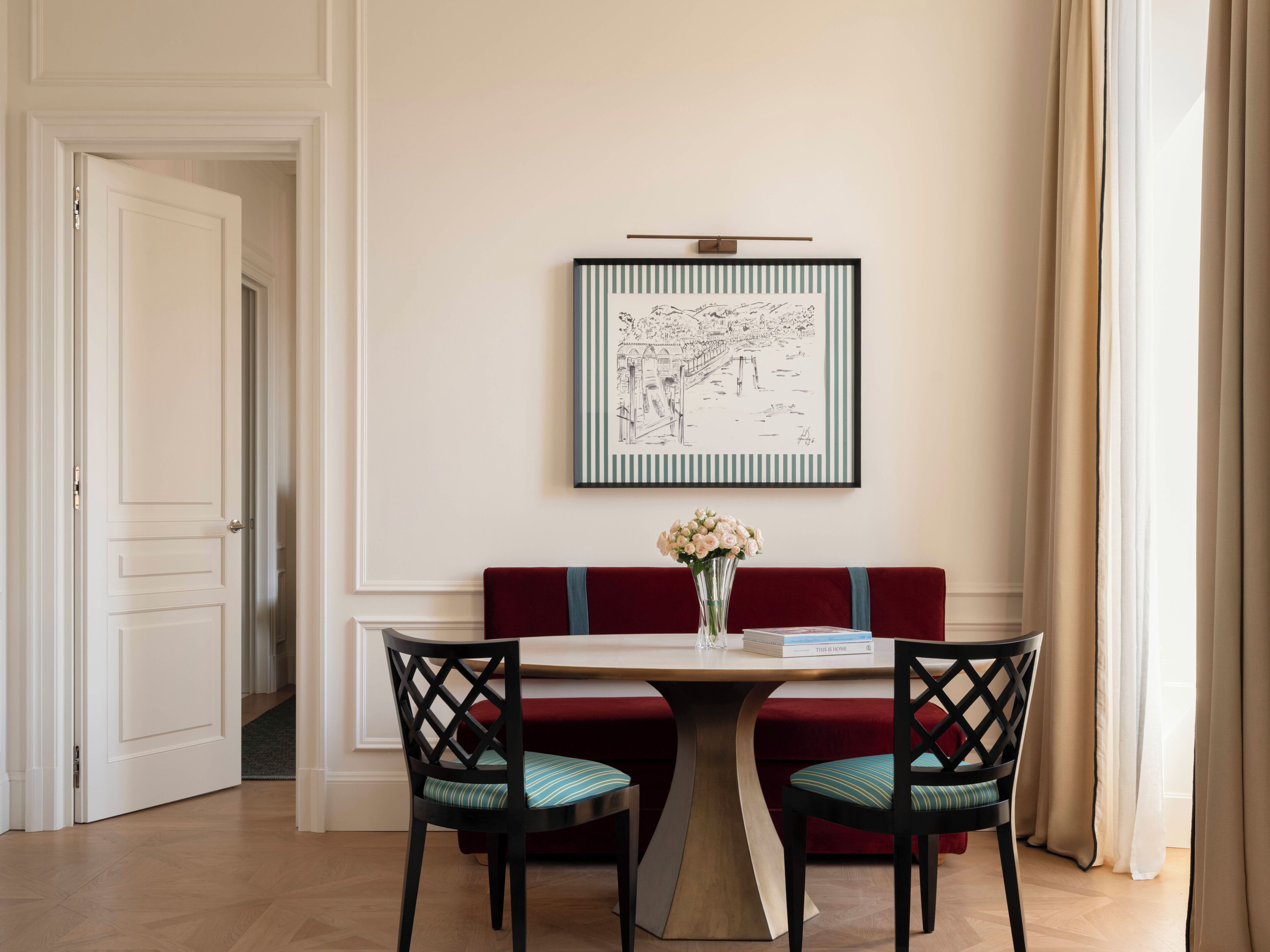 Un espace repas comprenant une table, des chaises et une œuvre d’art encadrée accrochée au mur.