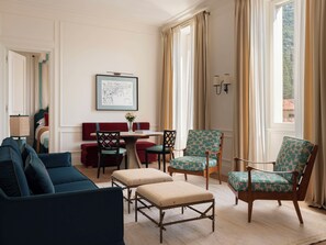 Una habitación con sofá, sillas, una mesa y vistas al exterior.