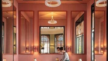 Interior de restaurante con paredes a rayas, asientos acolchados rojos y un espejo central.