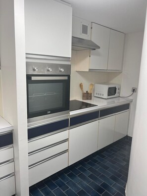 A kitchen with a built-in oven, microwave, and cabinets. - Les Appartements De Lina - L'Architek (La Grande-Motte)