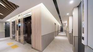 A modern hotel corridor with elevators, a reception area, and a clean, well-lit environment. - Incheon Hound New Town Branch (Incheon)
