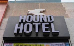 A sign for the HOUND HOTEL with a stylized dog logo above the name.