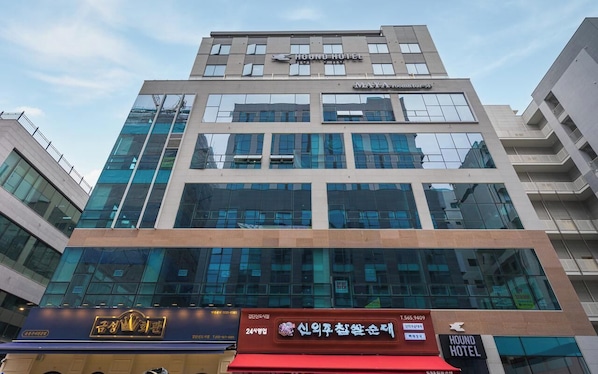 A modern building with a HOUND HOTEL sign at the top.