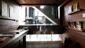 Un interior moderno con paredes de madera, una escalera de cristal y vistas al exterior.