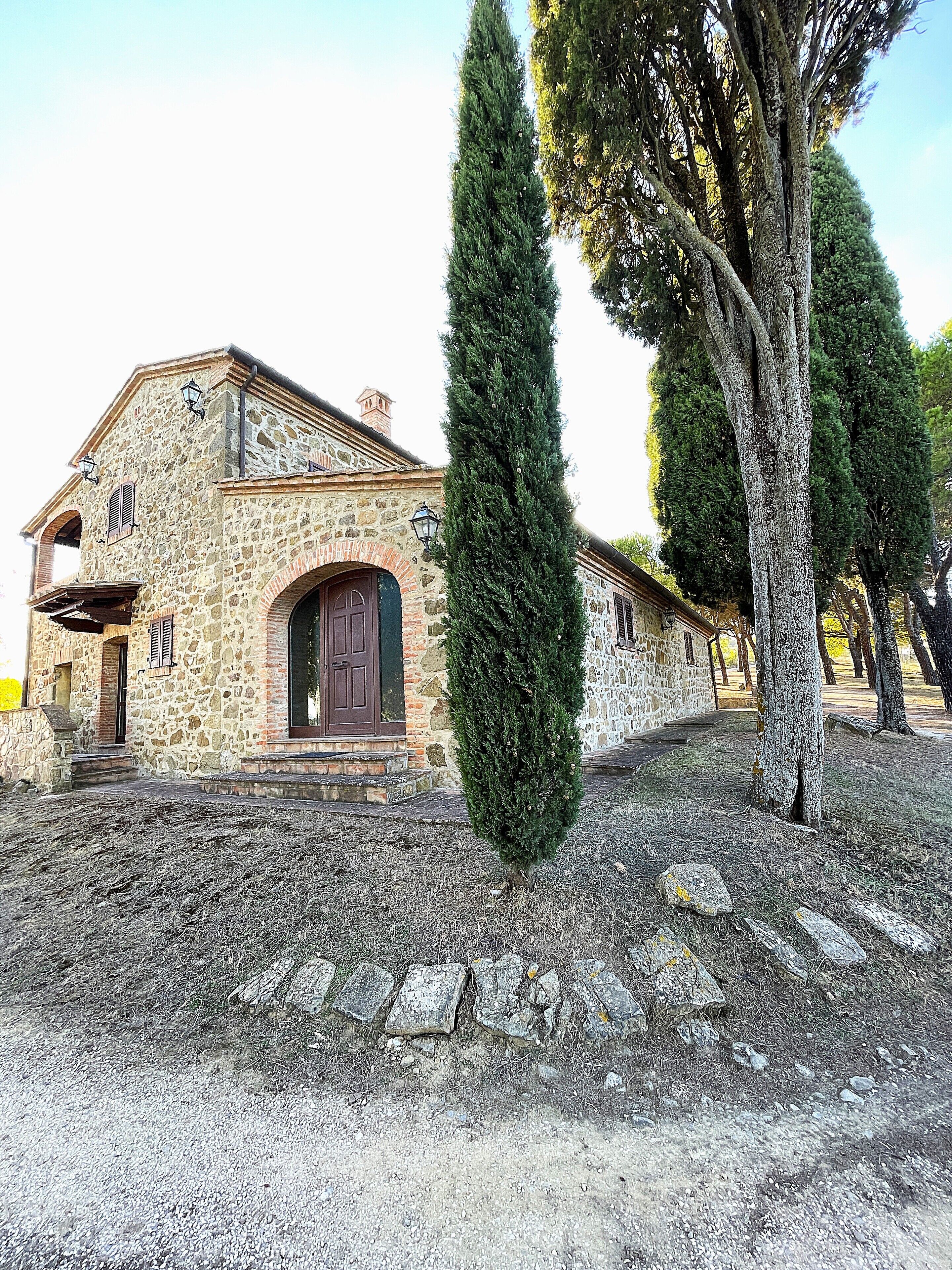 A stone building with a central arched doorway, a small porch, and a stone roof.