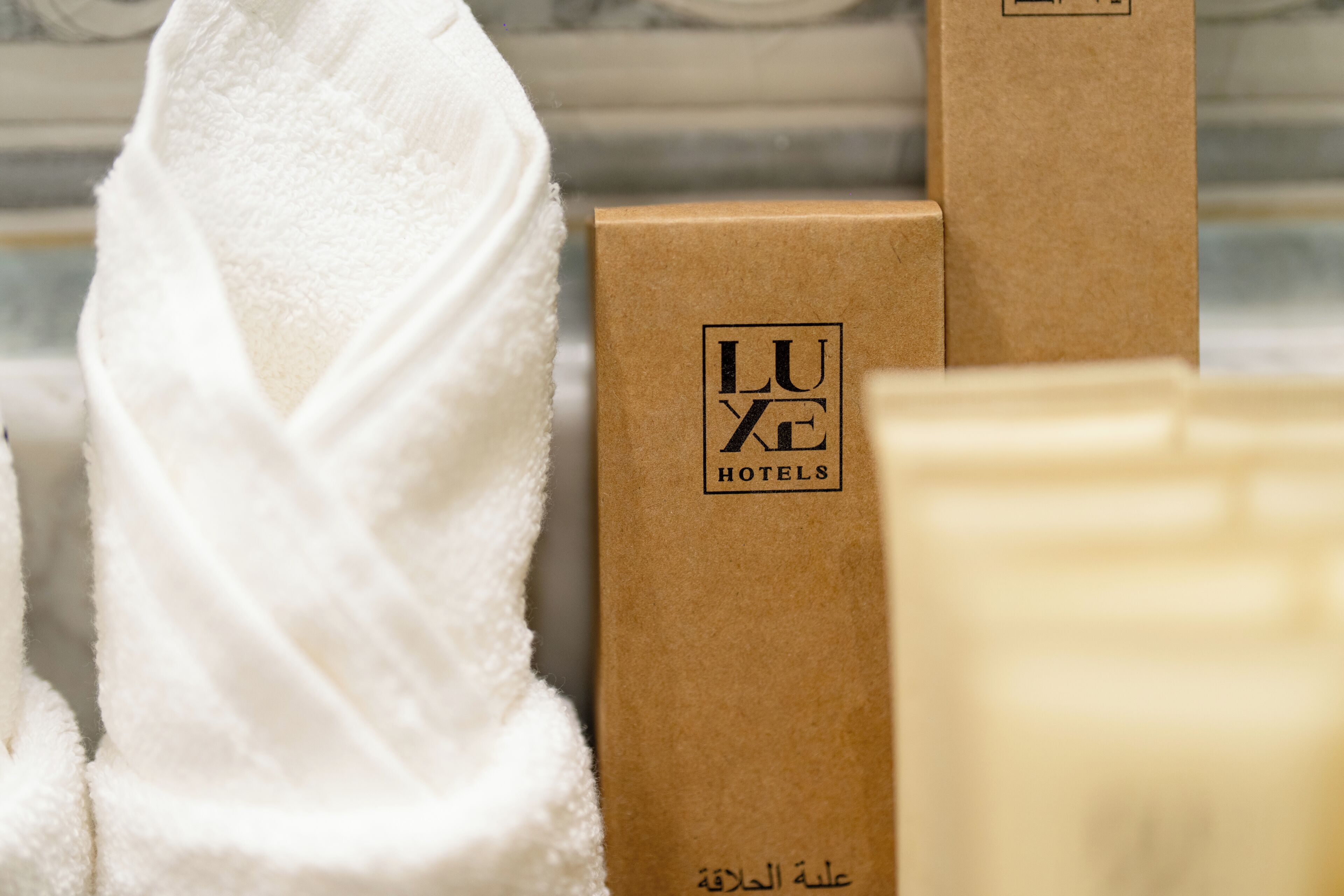 A towel and two brown boxes with 'LUXE HOTELS' text.