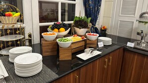 Montaje de bufé con diferentes alimentos y una cesta de fruta.