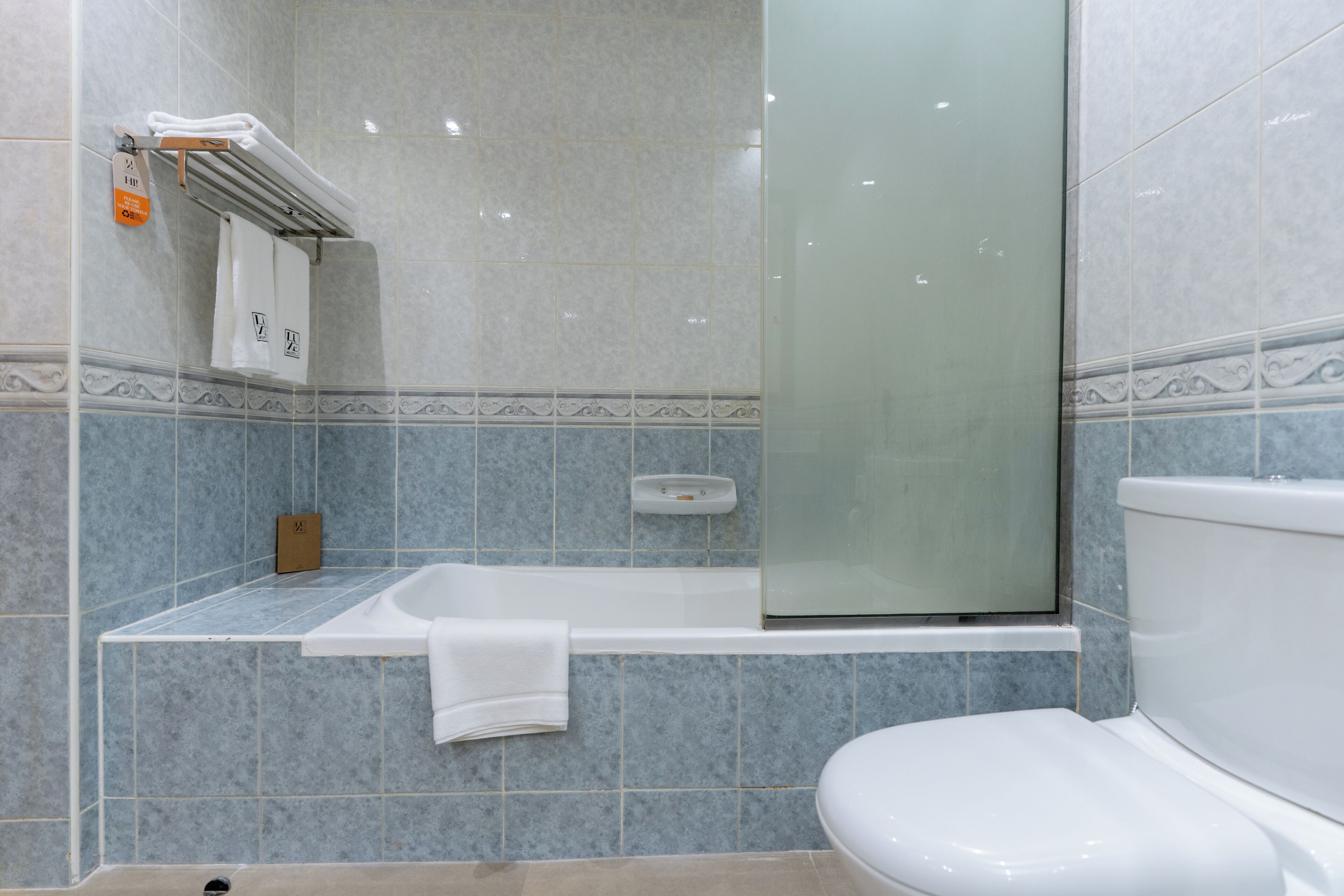 A bathroom with a bathtub, toilet, and glass shower enclosure.