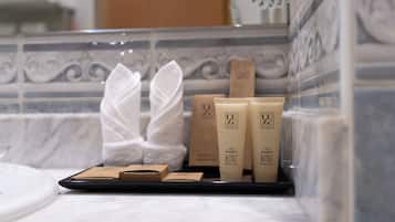 Toiletries on a tray in a bathroom with a tiled wall.