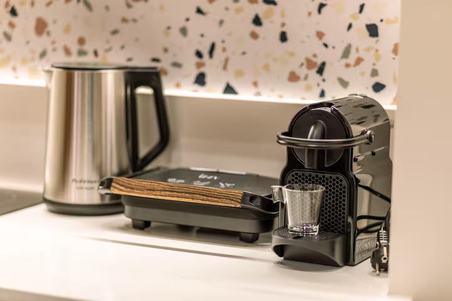 A coffee machine with a built-in grinder and a glass carafe on a countertop.