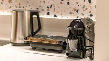 A coffee machine with a built-in grinder and a glass carafe on a countertop.
