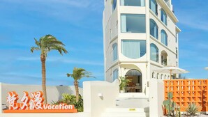 A modern multi-story building with a prominent entrance and a sign indicating a vacation destination. - Dali Fanxi Manhai Holiday Guesthouse (Dali)