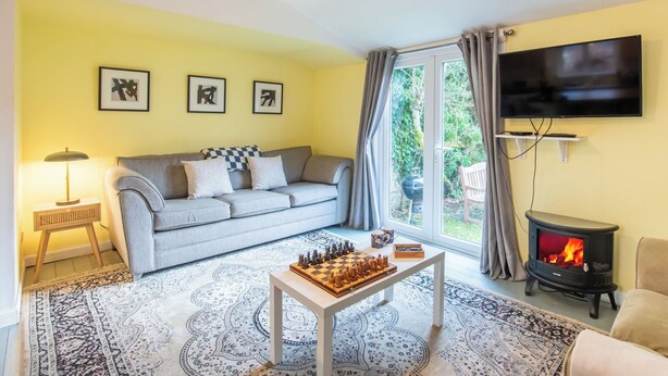 A living room with a sofa, a chess table, a TV, and a fireplace. - The Chalet by Interhome (Fort Augustus)