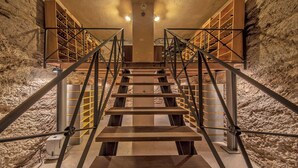 A staircase with metal railings and wooden steps leading to a wine cellar with shelves of wine bottles. - Luxury 7BR Villa | Private Pool & Lake Garda View | Limonaia dei Dogi | Gargnano (Gargnano)