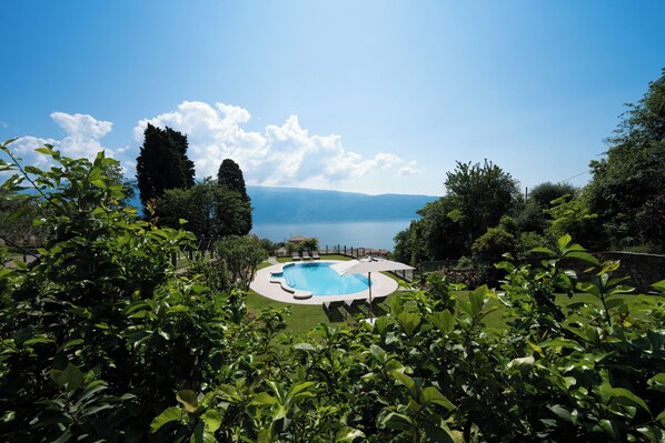 A swimming pool with a view of a lake and mountains in the background.