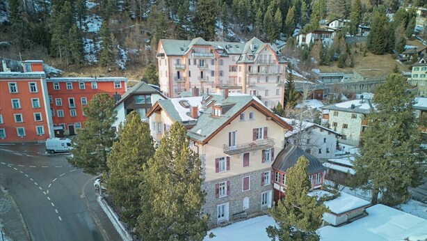 A multi-story building with a stone facade, multiple balconies, and a snow-covered roof. - Spacious 3-Bedroom Apartment with Balcony & Mountain Views in Champfèr (Champfèr)