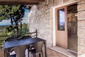 Outdoor dining - GuestHost - A welcoming and charming 71 square meters villa, perfect for four people, with a private entrance (two steps to access).The property is located in an extremely quiet location and is surrounded by the lush Sardinian nature: from the veranda yo (Baja Sardinia)