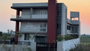 Un bâtiment moderne avec une enseigne indiquant « Infinity Resort & Restaurant ».