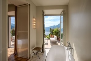 A modern bathroom with a bathtub, a shower, and a view of the outdoors. - Palazzo Genazzini (Bellagio)