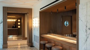 A modern bathroom with a wooden vanity, a mirror, and three stools. - Palazzo Genazzini (Bellagio)