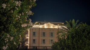 A historic building with a balcony, surrounded by lush greenery. - Palazzo Genazzini (Bellagio)