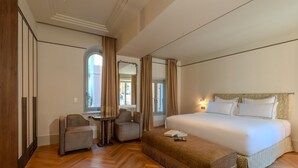 A hotel room with a large bed, two armchairs, a small table, and a wardrobe. - Palazzo Genazzini (Bellagio)